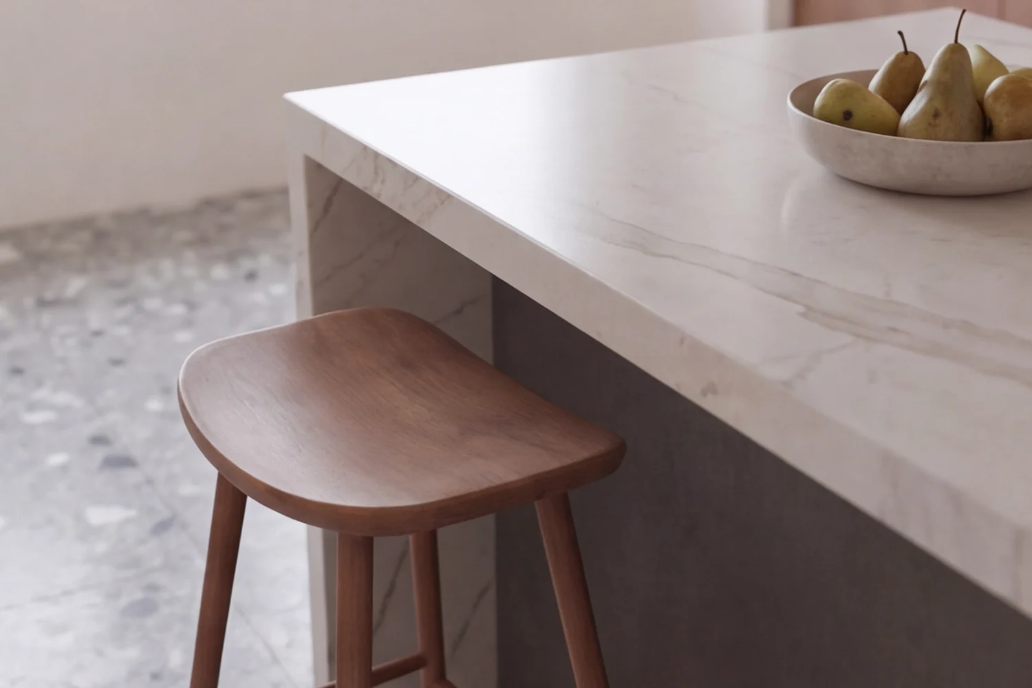A stool at the corner of the marble island